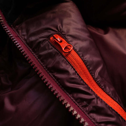 a close up detail photo of the altitude down parka's zippered internal chest pocket using ykk zippers
