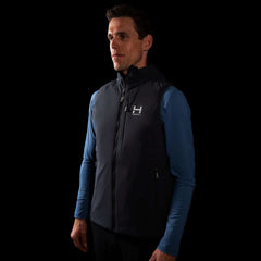 a fit photo of a person wearing the mens ascent stretch vest with 60g primaloft gold insulation in colorway DEEP SPACE with a mens pursuit longsleeve in MINDFUL BLUE underneath