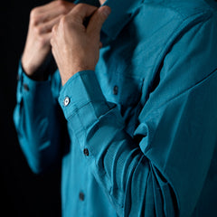 A close up fit photo showcasing the HIMALI mens jetsetter ultra-vent button down shirt in the colorway ELECTRIC TEAL on a male model
