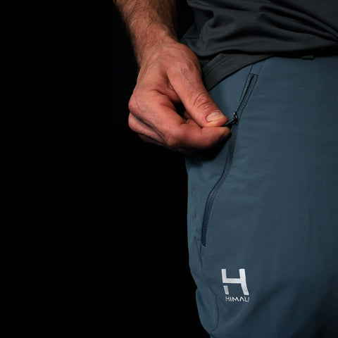 A fit photo of the HIMALI Mens Softshell Guide Flex Pant showing the zippered pocket