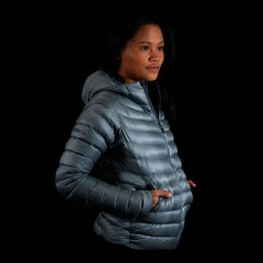 A fit photo of the womens Accelerator Down Jacket showing a woman using the YKK zippered hand pockets