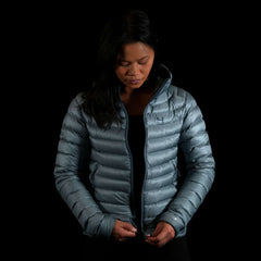 A fit photo of the womens Accelerator Down Jacket that shows a women using the center front YKK zipper