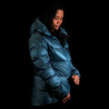 A fit photo of a person wearing the altitude down jacket as seen from the side. the wearing is using the ykk zippers