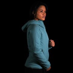 a fit photo of a person wearing the womens ascent stretch hoodie with 100g primaloft gold insulation & using the ykk zipper