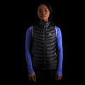 fit photo of the Women's Focus Down Vest in colorway Deep Space with 700 fill power hyperdry RDS certified down with a lupine pursuit longsleeve underneath