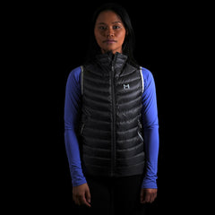 fit photo of the Women's Focus Down Vest in colorway Deep Space with 700 fill power hyperdry RDS certified down with a lupine pursuit longsleeve underneath