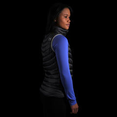 fit photo (side view) of the Women's Focus Down Vest in colorway Deep Space with 700 fill power hyperdry RDS certified down with a lupine pursuit longsleeve underneath