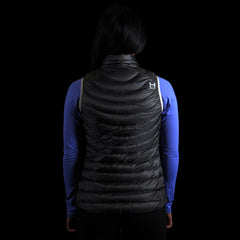 fit photo (back view) of the Women's Focus Down Vest in colorway Deep Space with 700 fill power hyperdry RDS certified down with a lupine pursuit longsleeve underneath