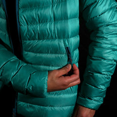 A fit photo of a person wearing the peak 7 down jacket as seen from the front & the person is using the external hand pocket using a YKK zipper. This pocket can easily fit your phone