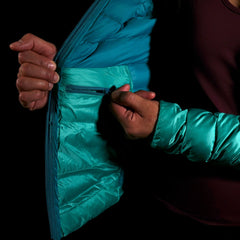 A fit photo of a person wearing the peak 7 down jacket as seen from the front & the person is using the internal pocket using a YKK zipper. This pocket can easily fit your phone