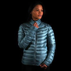 A fit photo of the womens Accelerator Down Jacket that shows a women using the center front YKK zipper