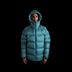 A fit photo of a person wearing the altitude down jacket as seen from the front wearing the helmet compatable hood & hilighting the oversized fit designed for layering