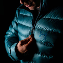 a fit photo of the mens accelerator down jacket that shows a man using the front center YKK zipper.